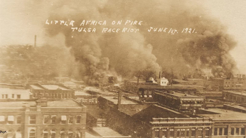 Archival photo of Greenwood District with smoke pouring from it.