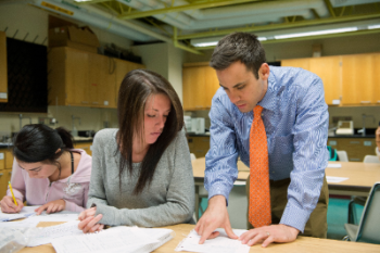 Female student and male teacher in classroom