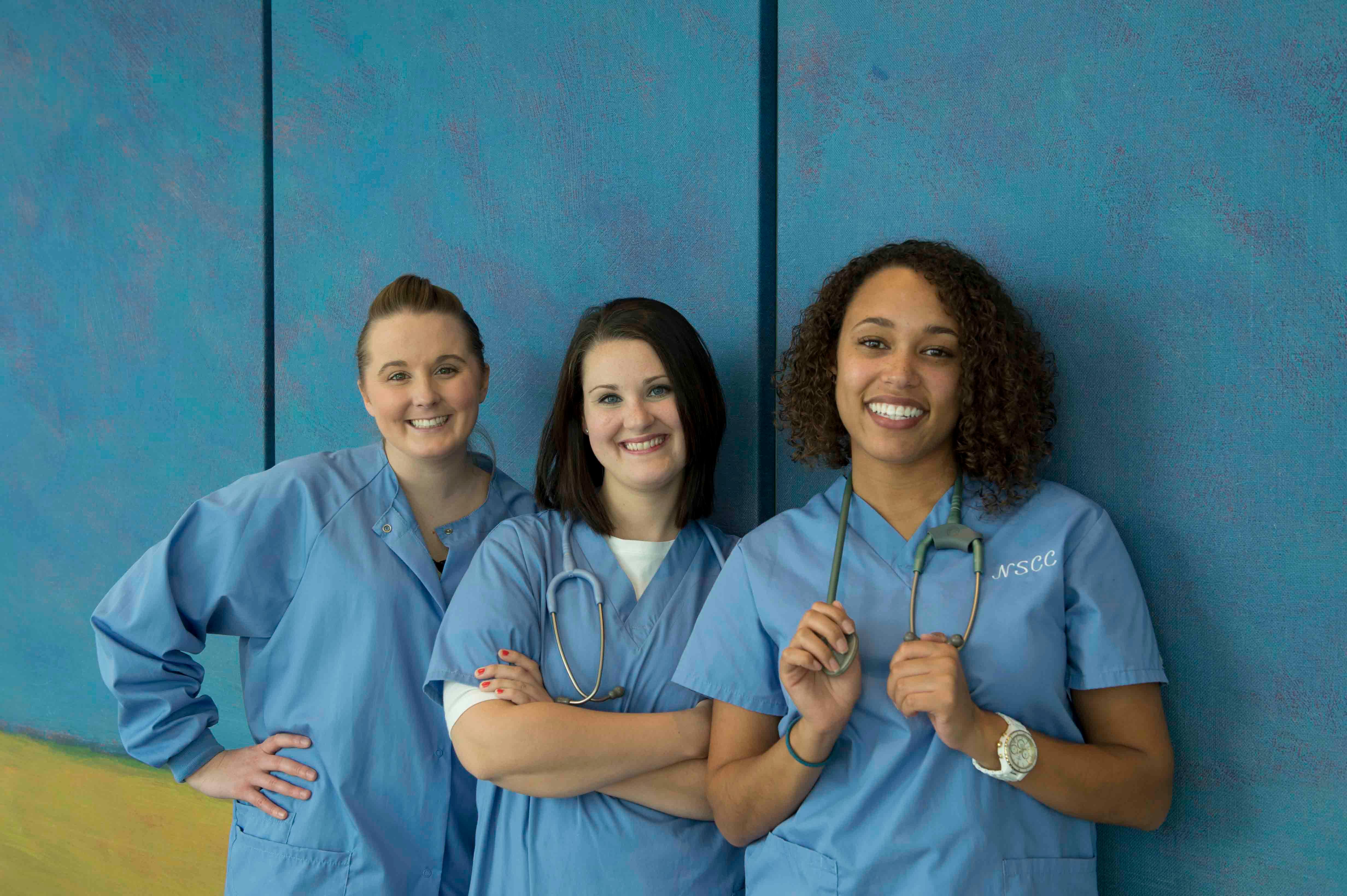 Three nursing students in scrubs