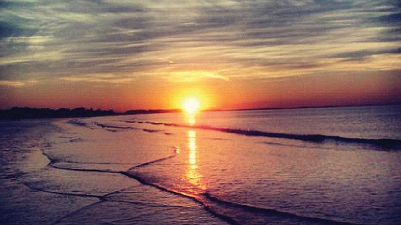 Photo of a sunset over the ocean and beach