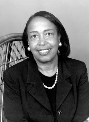 Black and white photo of a smiling Dr. Bath in her office.