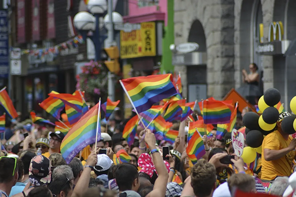 tops of head and flags waving at pride parade