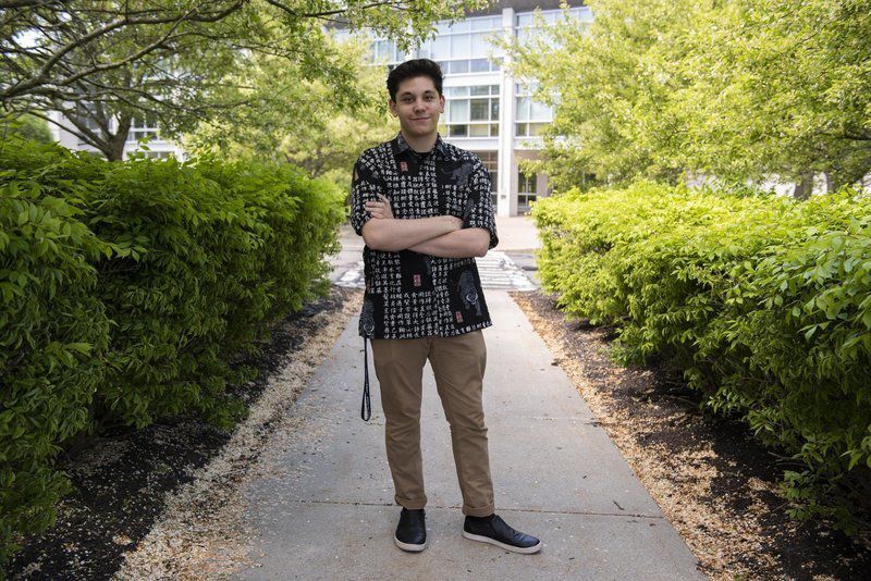 Photo of Harrison Davis with a checkered shirt, standing outside at the Danvers Campus.