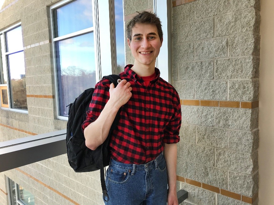 Photo of Ryan Duggan wearing a backpack inside at the Berry Building on the Danvers Campus.