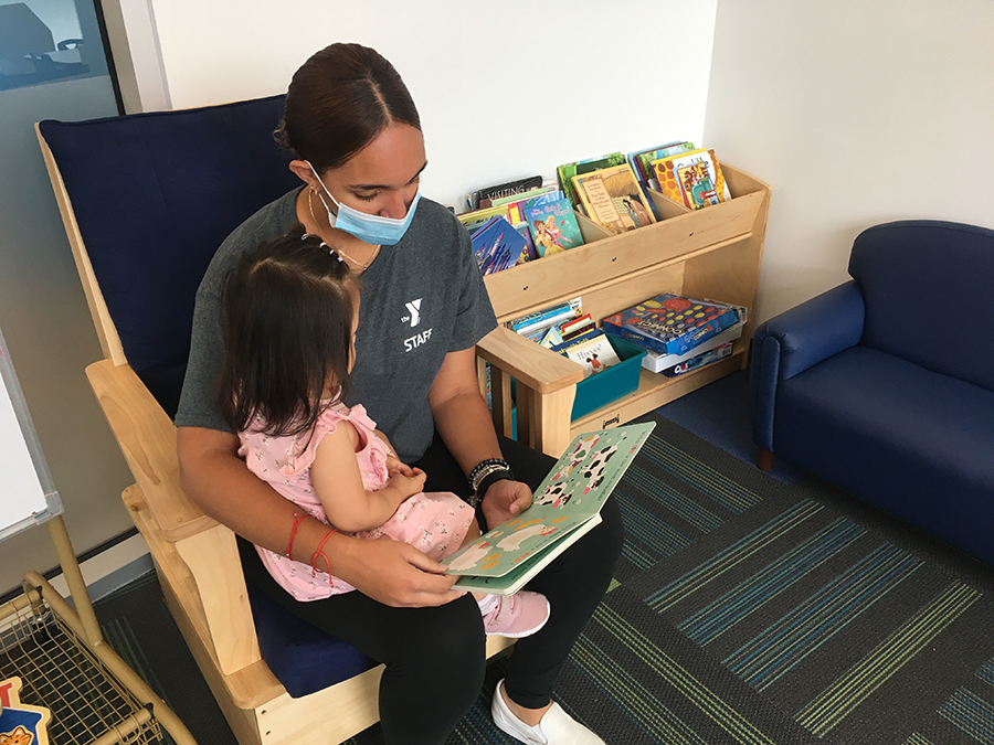 woman reading book to child