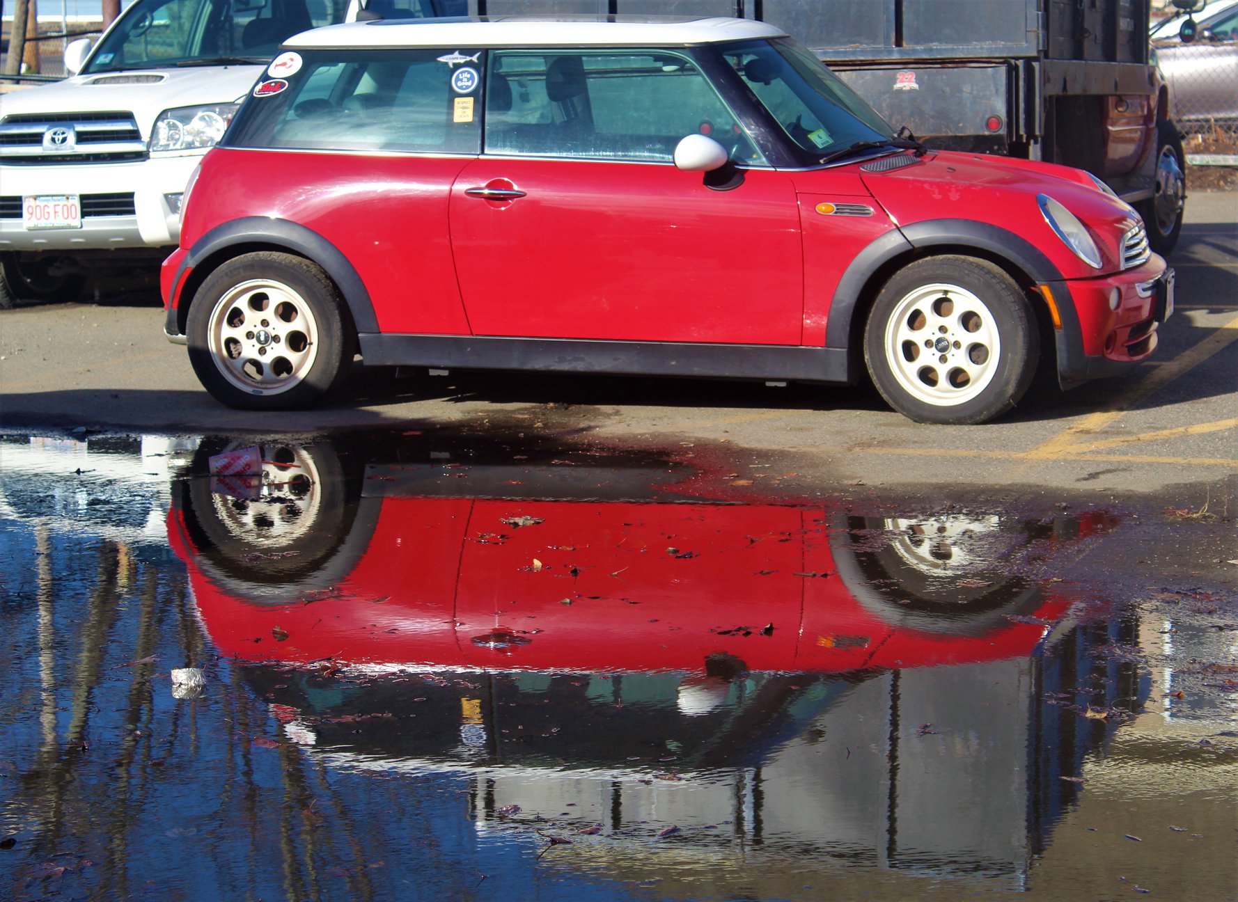 picture of car and reflection from large puddle beside it