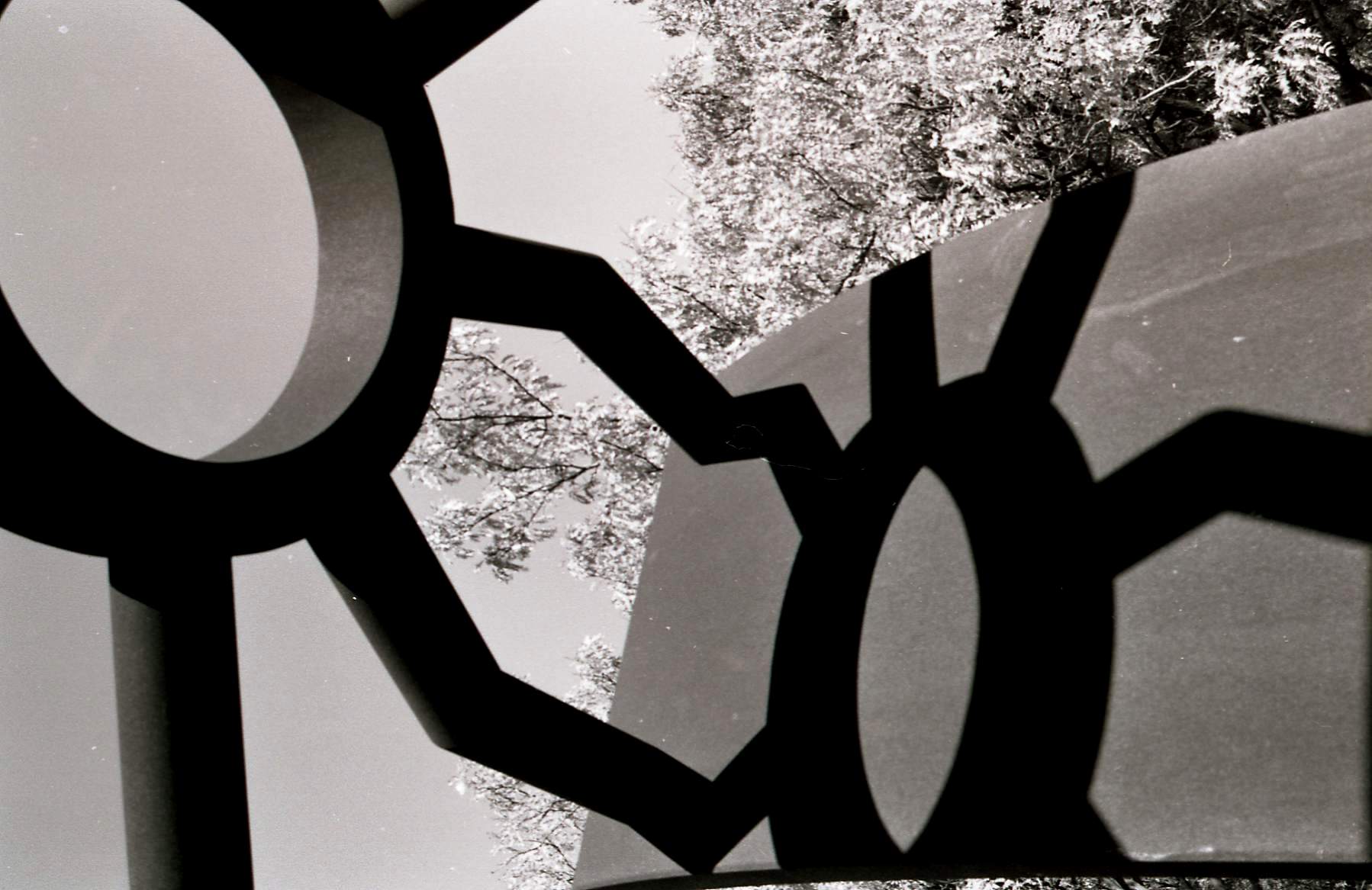 black and white photo of light coming through geometric oranate windows