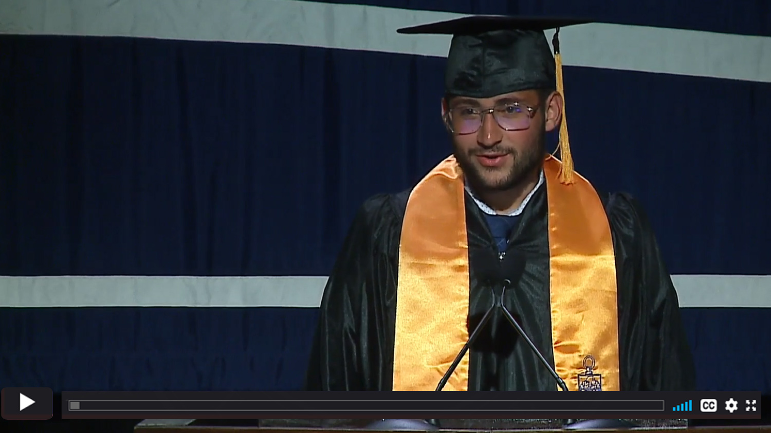 Luciano in cap and gown at the podium.