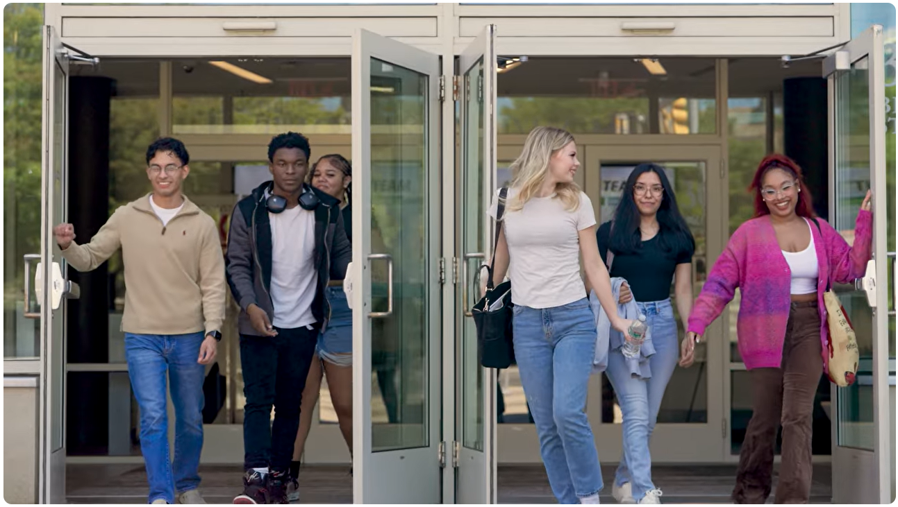 Group of smiling students walking out of North Shore Community College Lynn Campus