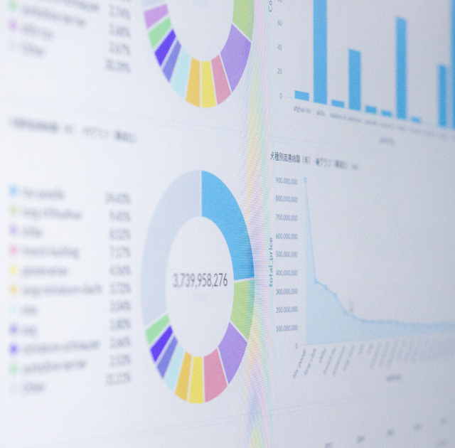 A computer screen displays a pie chart and a line graph, indicating data analysis and performance metrics