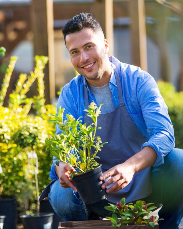Lanscape professional smiling while tending to the garden