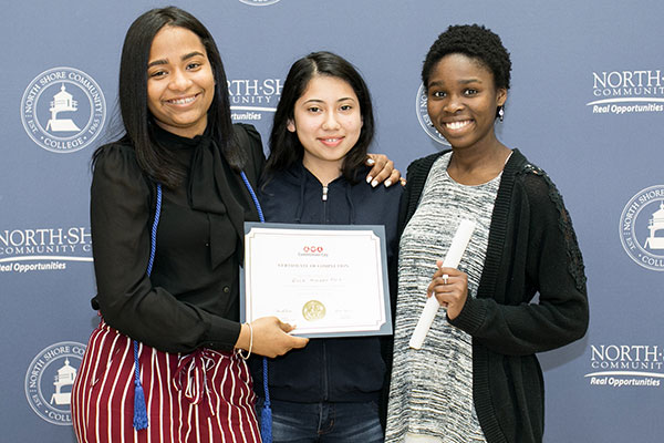 Three students with certificates