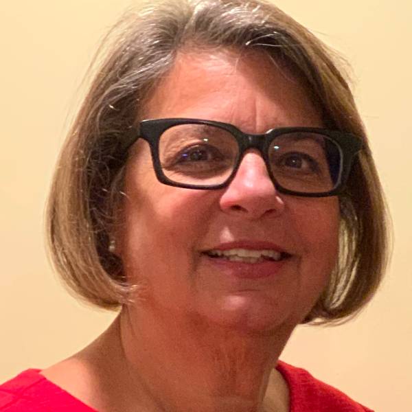 Portrait of Laura Kurzok, Foundation VP, with black rimmed glasses and a red blouse.