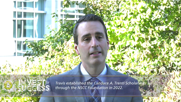 Video still of Travis infornt of some outside greenery on a sunny day