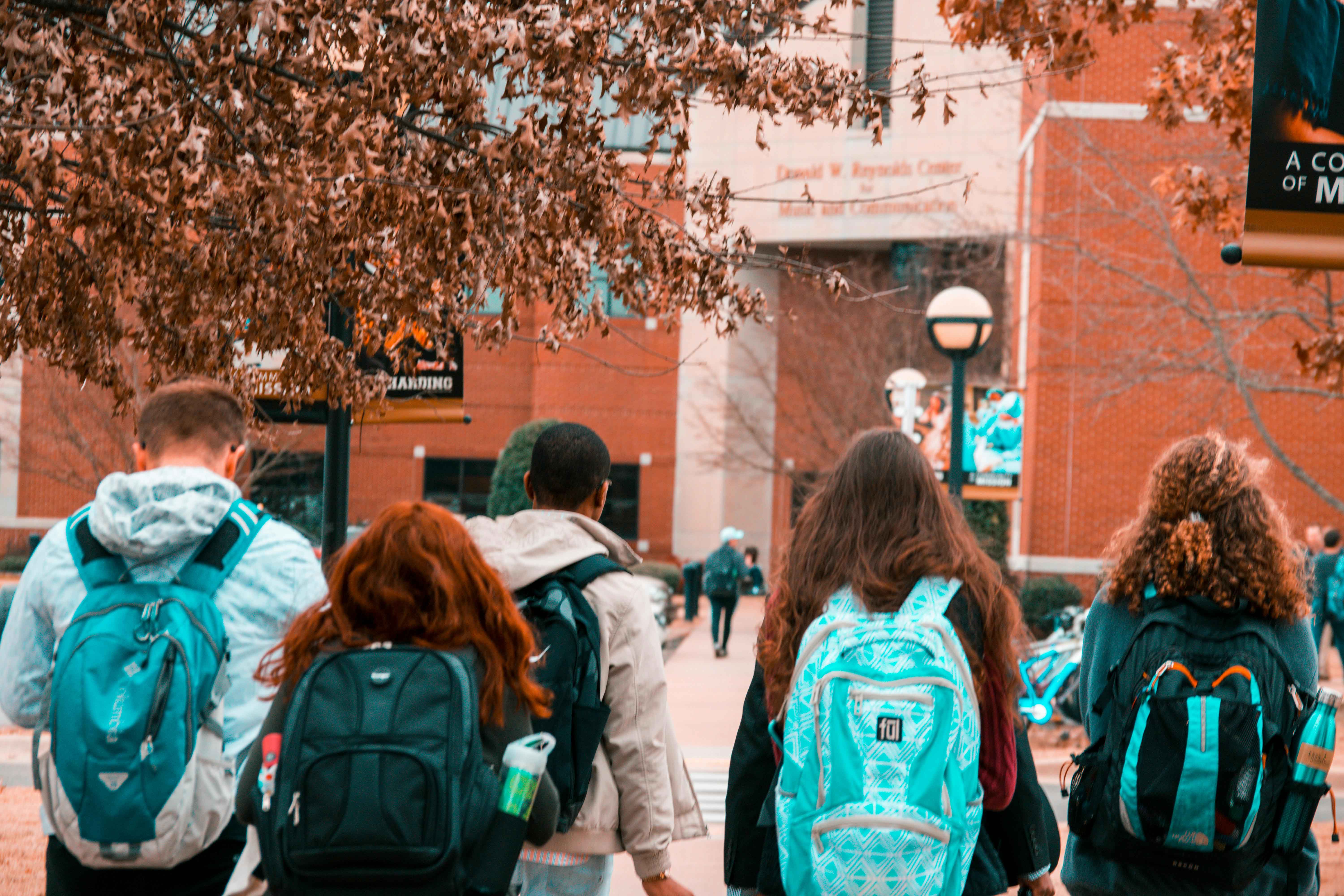 Students wearing backpacks walk to school