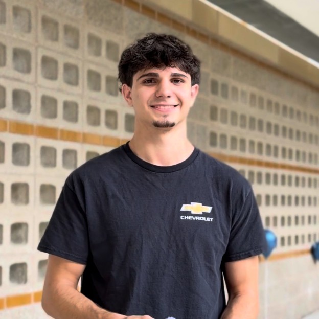 A person in a black chevrolet t-shirt smiles at the camera