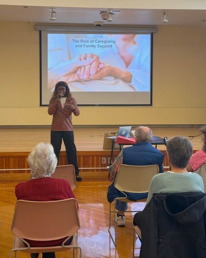 Bridget Ngu-Atem presents slides in front of an audience at the Beverly Senior Center