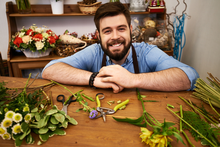 Portrait of happy florist in his own flower shop smiling