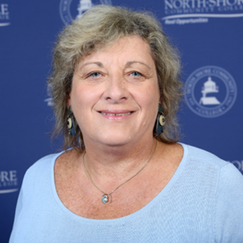 Portrait of Janice in blue sweater in front of blue background