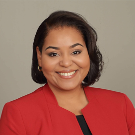 Portrait of Dr. Mezquita in red suit on a gray background