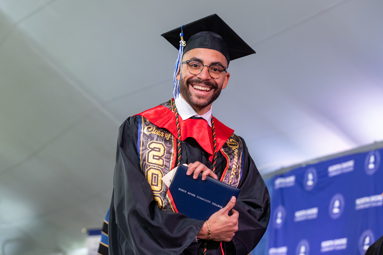 TRIO student holding diploma at graduation