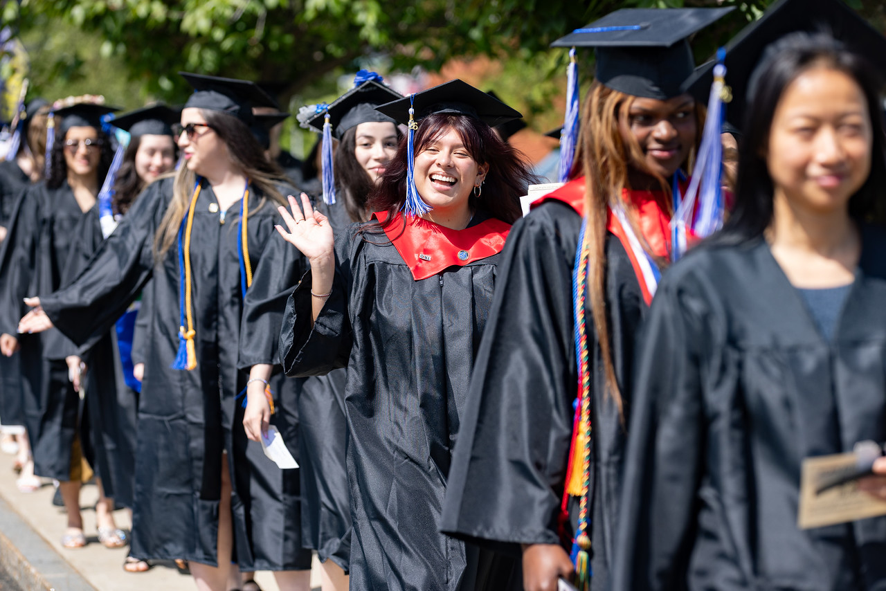 TRIO student waving in line at graduation